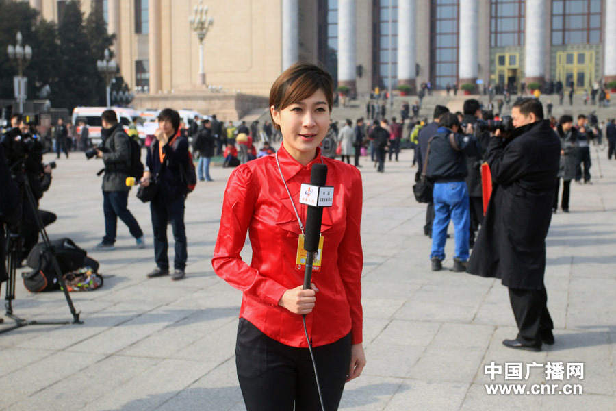A television host wearing red shirt reports at Tiananmen Square. (Photo/www.cnr.cn)