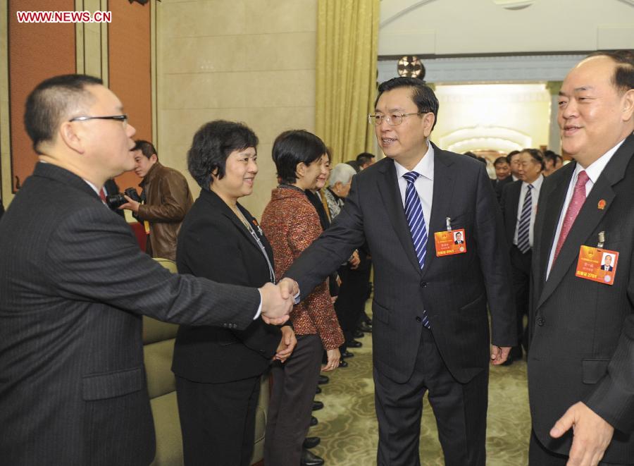 Zhang Dejiang (2nd R, front), a member of the Standing Committee of the Political Bureau of the Communist Party of China (CPC) Central Committee, joins a discussion with deputies from south China's Macao Special Administrative Region, who attend the first session of the 12th National People's Congress (NPC), in Beijing, capital of China, March 7, 2013. (Xinhua/Xie Huanchi)