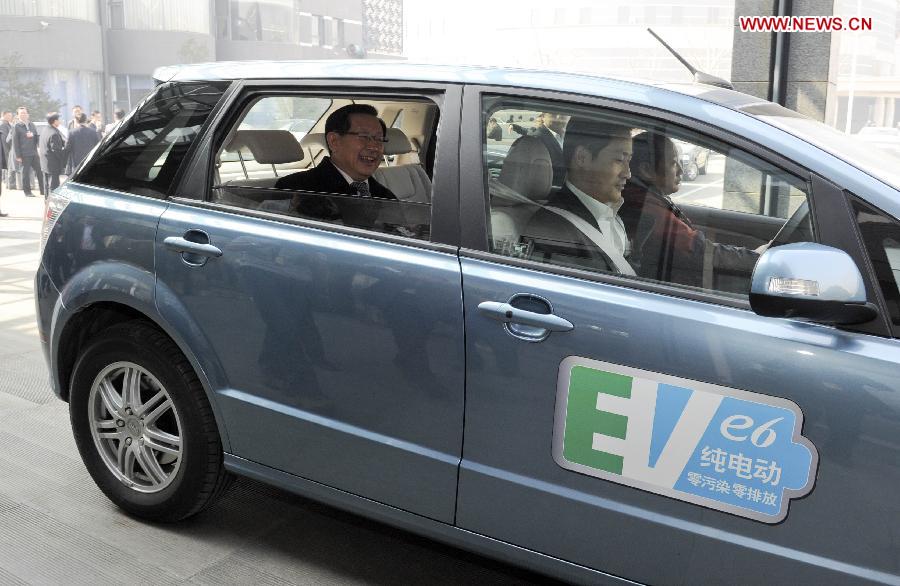 Wan Gang (L), the minister of science and technology, takes an electric vehicle (EV) to leave after a panel discussion in Beijing, capital of China, March 7, 2013. The minister said to reporters that zero-emission electric vehicles had been sold in Chinese market with an affordable price. (Xinhua/Zhang Duo)