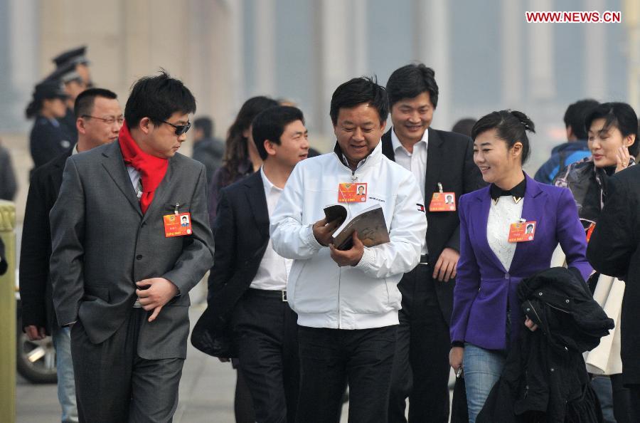 Zhu Jun (C), a member of the 12th National Committee of the Chinese People's Political Consultative Conference (CPPCC), along with other CPPCC members, arrive at the Tian'anmen Square in Beijing, capital of China, March 7, 2013. The second plenary meeting of the first session of the 12th CPPCC National Committee will be held in Beijing on Thursday. (Xinhua/Guo Chen) 