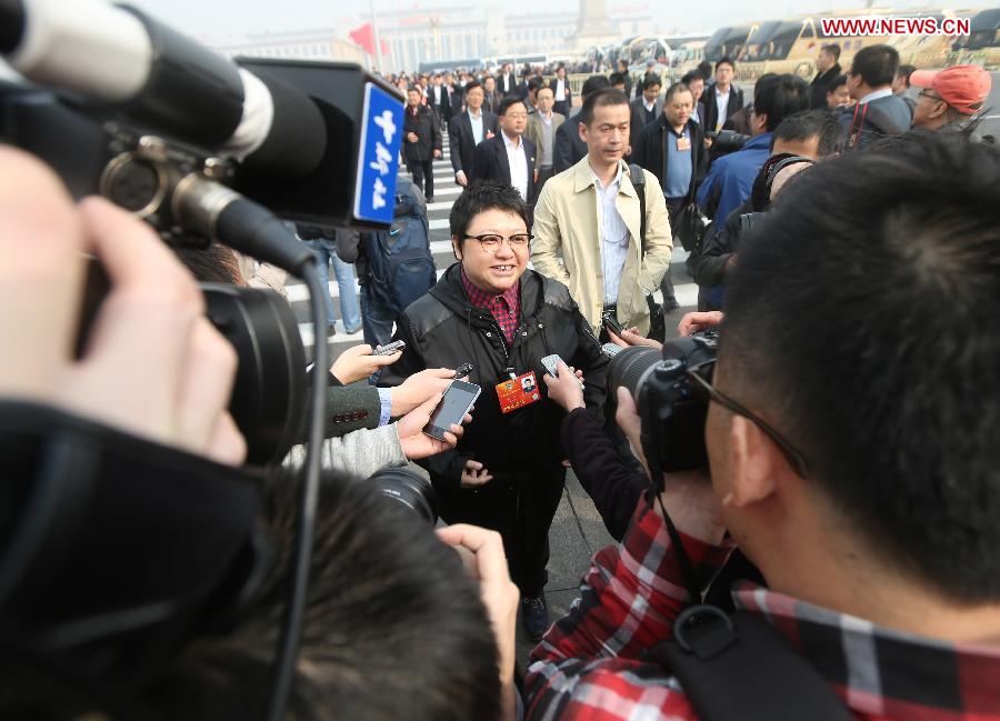 Han Hong (C), a member of the 12th National Committee of the Chinese People's Political Consultative Conference (CPPCC), is interviewed at the Tian'anmen Square in Beijing, capital of China, March 7, 2013. The second plenary meeting of the first session of the 12th CPPCC National Committee was held in Beijing on Thursday. (Xinhua/Xing Guangli) 