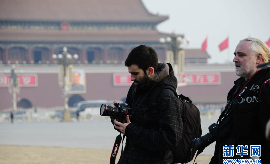 Foreign reporters take pictures near the Great Hall of the People in Beijing on March 5, 2013. Over 3,000 reporters have registered for the coverage of the First Session of the Chinese People's Political Consultative Conference (CPPCC) and the First Session of the 12th National People's Congress (NPC), taking place from March 3 to 17. More than 800 of the reporters have flown in from overseas, according to Xinhua statistics.