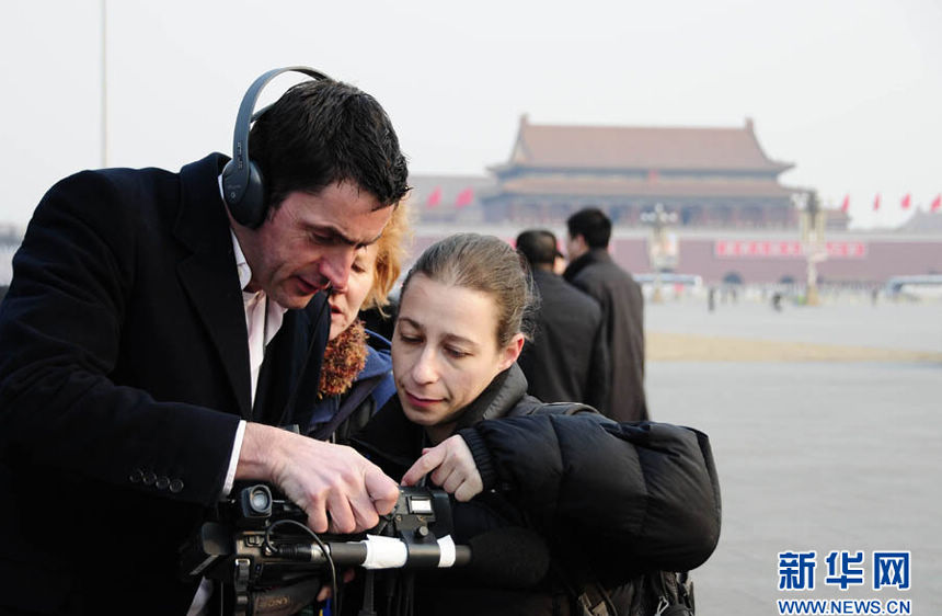 Foreign reporters take pictures near the Great Hall of the People in Beijing on March 5, 2013. Over 3,000 reporters have registered for the coverage of the First Session of the Chinese People's Political Consultative Conference (CPPCC) and the First Session of the 12th National People's Congress (NPC), taking place from March 3 to 17. More than 800 of the reporters have flown in from overseas, according to Xinhua statistics.