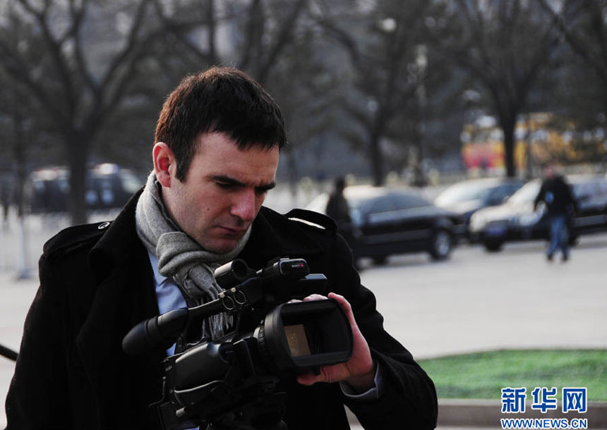 A foreign reporter takes pictures near the Great Hall of the People in Beijing on March 5, 2013. Over 3,000 reporters have registered for the coverage of the First Session of the Chinese People's Political Consultative Conference (CPPCC) and the First Session of the 12th National People's Congress (NPC), taking place from March 3 to 17. More than 800 of the reporters have flown in from overseas, according to Xinhua statistics.