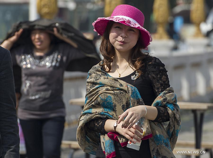 A woman walks on Nanbin street in Chongqing Municipality, southwest China, March 7, 2013. The highest temperature rose to 28 degrees Celsius in Chongqing on Thursday. (Xinhua/Chen Cheng)