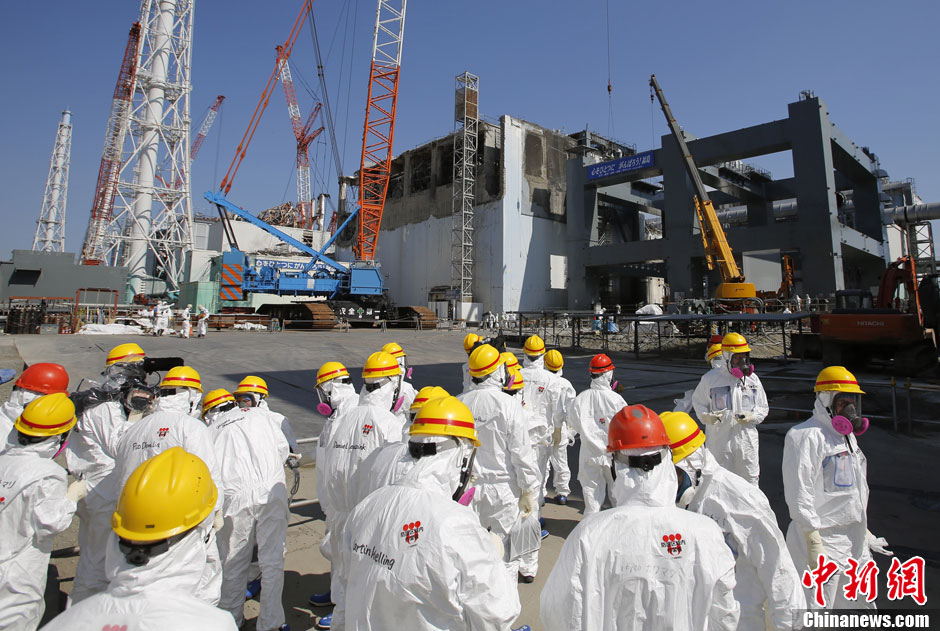 Workers stand near the multi-nuclide removal facility being constructed at Tokyo Electric Power Co.'s tsunami-crippled Fukushima Dai-ichi nuclear power plant in Okuma, Fukushima prefecture, Wednesday, March 6, 2013, ahead of the second anniversary of the March 11 earthquake and tsunami. Some 110,000 people living around the nuclear plant were evacuated after the massive disasters knocked out the plant's power and cooling systems, causing meltdowns in three reactors and spewing radiation into the surrounding air, soil and water. (Chinanews.com)