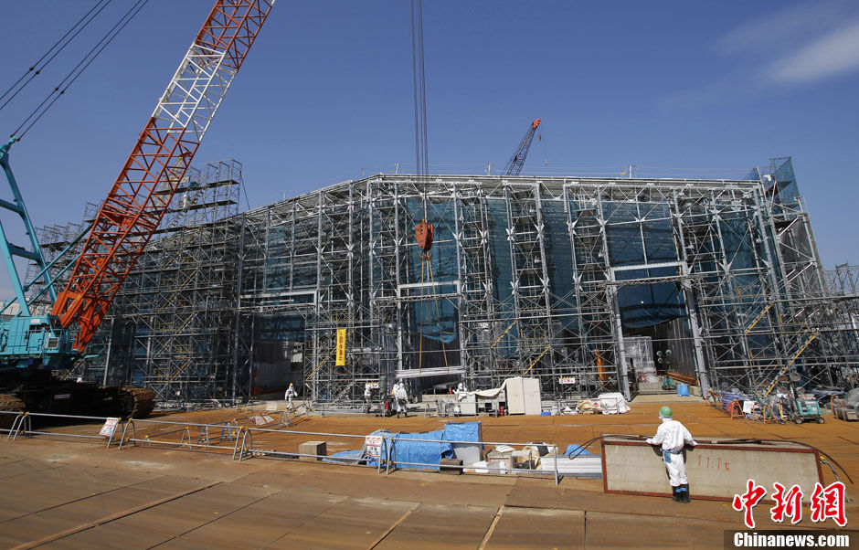 Workers stand near the multi-nuclide removal facility being constructed at Tokyo Electric Power Co.'s tsunami-crippled Fukushima Dai-ichi nuclear power plant in Okuma, Fukushima prefecture, Wednesday, March 6, 2013, ahead of the second anniversary of the March 11 earthquake and tsunami. Some 110,000 people living around the nuclear plant were evacuated after the massive disasters knocked out the plant's power and cooling systems, causing meltdowns in three reactors and spewing radiation into the surrounding air, soil and water. (Chinanews.com)