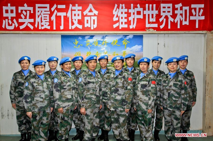 Female members of the medical team of the 14th batch of Chinese peacekeeping force for Liberia pose for a group photo in Zwedru, Liberia, March 8, 2013, the International Women's Day. There are 13 females among the 43 members of the medical personnel group. (Xinhua/Gao Lei)