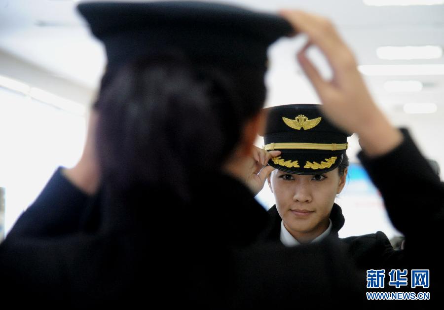 Li adjusts her clothes in front of a mirror on March 7, 2013. Li Ying, born in 1986, was formally transferred to the North Branch of Southern Airline in June 2011 as copilot in the Airbus A320 fleet. She piloted the airplane from Shenyang to Shenzhen as a captain for the first time on March 8, 2013.(Photo/Xinhua) 