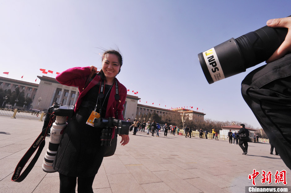 A female journalist covering the NPC and CPPCC sessions poses for photo.（Photo/CNS）