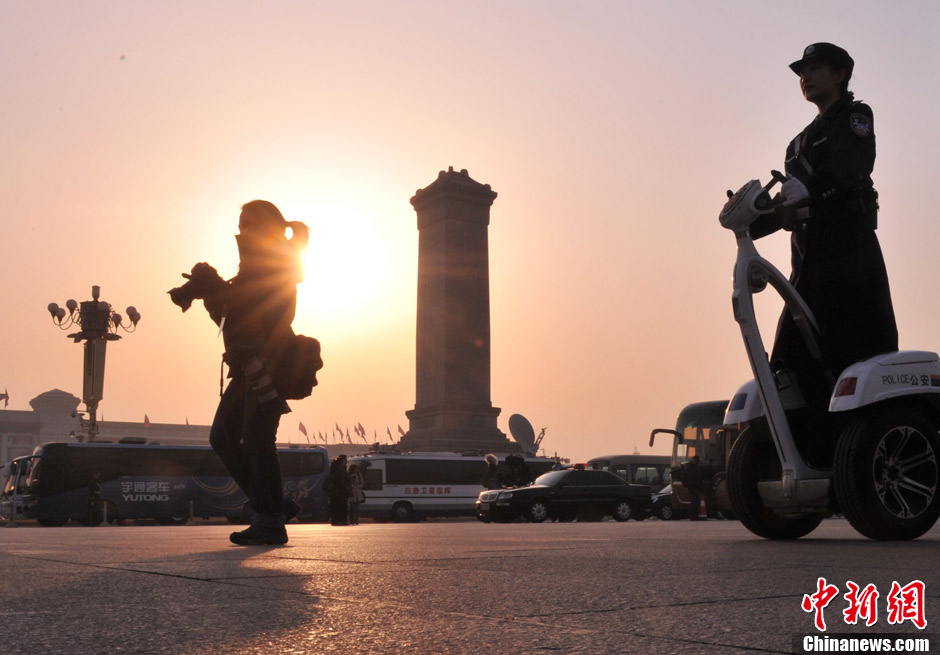 A female journalist covering the NPC and CPPCC sessions walks at Tiananmen Square. (Photo/CNS)