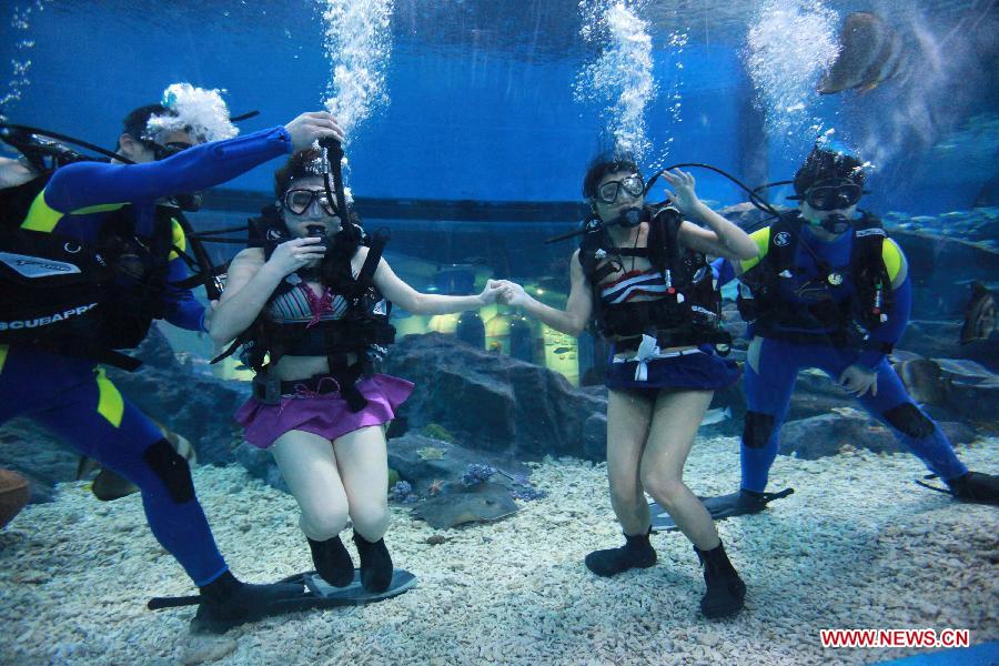 Local citizens Qu Di (L) and Wang Fang dive under professional guidance to enjoy a special Women's Day at the Polar Ocean World of Wuhan, capital of central China's Hubei Province, March 8, 2013. (Xinhua/Wang Zhenwu) 