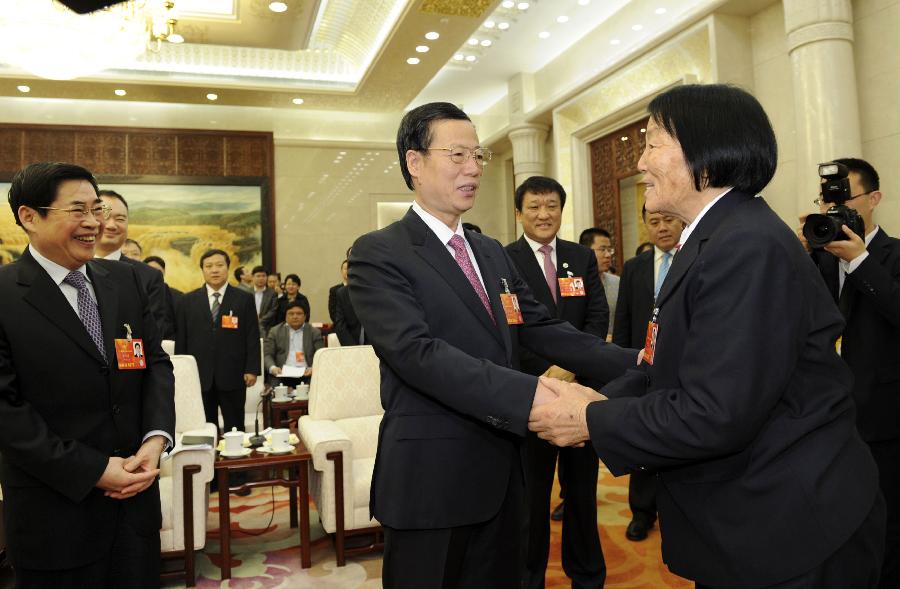 Zhang Gaoli (C), a member of the Standing Committee of the Political Bureau of the Communist Party of China (CPC) Central Committee, shakes hands with Shen Jilan, a deputy to the 12th National People's Congress (NPC), while joining a discussion with the NPC deputies from north China's Shanxi Province, who attend the first session of the 12th NPC, in Beijing, capital of China, March 8, 2013. (Xinhua/Xie Huanchi)