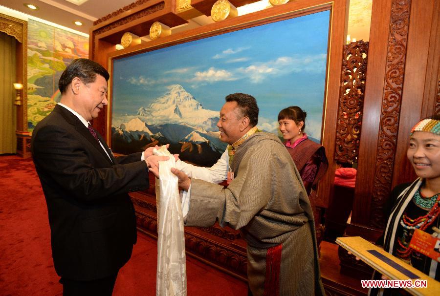 Xi Jinping (L), general secretary of the Central Committee of the Communist Party of China (CPC), receives a hada, a white silk scarf symbolizing respect and blessing, from a deputy to the 12th National People's Congress (NPC) from southwest China's Tibet Autonomous Region, in Beijing, capital of China, March 9, 2013. Xi joined a discussion with the Tibet delegation attending the first session of the 12th NPC in Beijing on Saturday. (Xinhua/Ma Zhancheng)