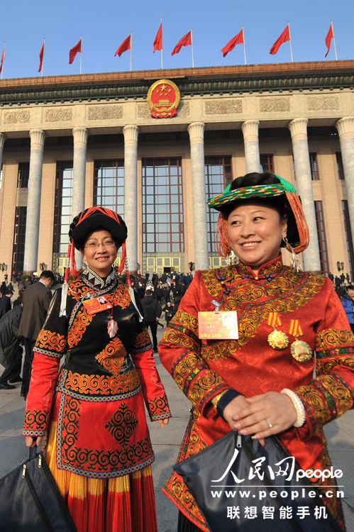 Two female deputies wearing traditional ethnic minority costumes during the opening meeting of the first session of the 12th National People's Congress (NPC) at the Great Hall of the People in Beijing, capital of China, March 5, 2013. (People’s Daily Online/Weng Qiyu)