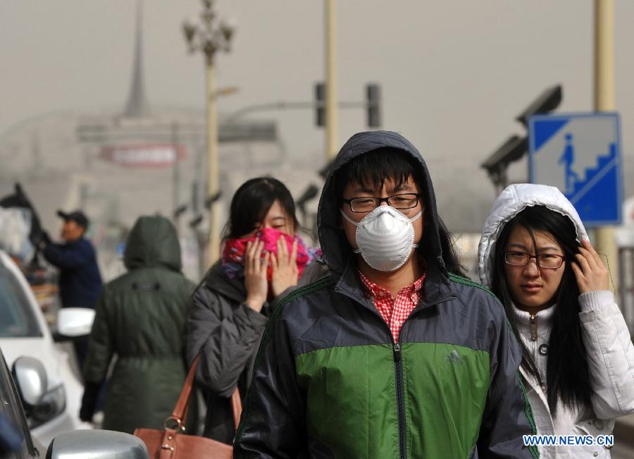 A man walks on the street wearing a mask in Beijing, capital of China, March 9, 2013. A cold front brings strong wind as well as sand and dust to Beijing on March 9. (Xinhua/Gong Lei)