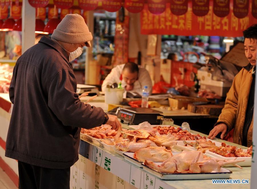 A customer purchases chicken at a market in Changchun, capital of northeast China's Jilin Province, March 9, 2013. China's consumer price index (CPI), a main gauge of inflation, grew 3.2 percent year on year in February, the highest level in ten months, the National Bureau of Statistics announced Saturday. (Xinhua/Zhang Nan)