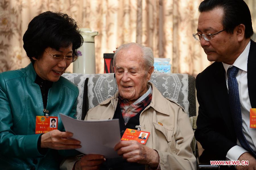 Members of the 12th National Committee of the Chinese People's Political Consultative Conference (CPPCC) Li Dongdong (L) and Akbar Mijit (R) read materials with Sidney Shapiro at Shapiro's home in Beijing, capital of China, March 9, 2013. Members of the 12th CPPCC National Committee on Saturday visited the 98-year-old American-born translator Shapiro, a CPPCC member absent from the ongoing session due to poor physical condition. Shapiro was born in New York in 1915. He first came to China in 1947 and was granted Chinese citizenship in 1963. After the People's Republic of China was founded in 1949, Shapiro devoted himself to translating Chinese literature. He gained his reputation with his English translation of the Chinese classic "Outlaws of the Marsh". Shapiro also rounded off the English versions of modern Chinese literary works including "The Family" and "The Immense Forest and Snowfield." (Xinhua/Jin Liangkuai)
