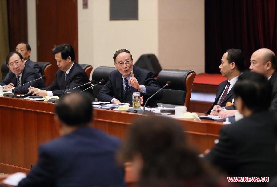 Wang Qishan (C), a member of the Standing Committee of the Political Bureau of the Communist Party of China (CPC) Central Committee, joins a discussion with deputies from northeast China's Heilongjiang Province, who attend the first session of the 12th National People's Congress (NPC), in Beijing, capital of China, March 9, 2013. (Xinhua/Lan Hongguang)