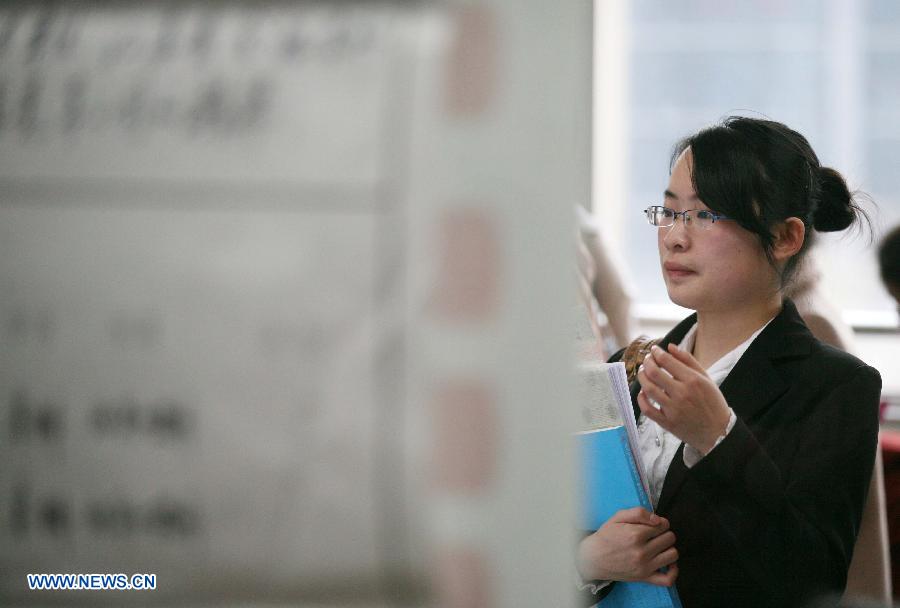 A college student looks through employment information at a job fair specially held for female graduates in Nanjing, capital of east China's Jiangsu Province, March 9, 2013. (Xinhua/Wang Xin)   