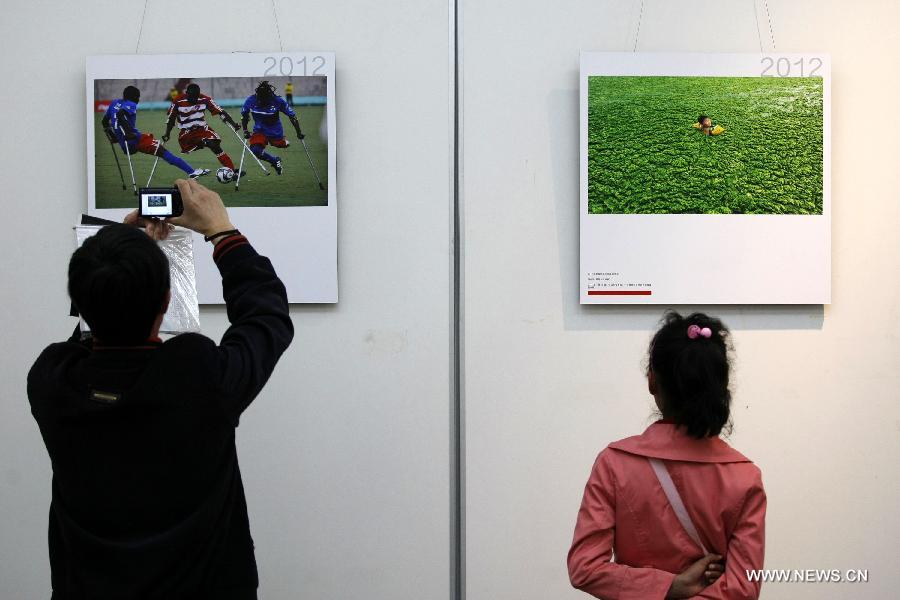 People visit a tour exhibition of the winning images of China International Press Photo Contest in the past years at the Wuxi Museum in Wuxi, east China's Jiangsu Province, March 9, 2013. (Xinhua/Sheng Guoping)