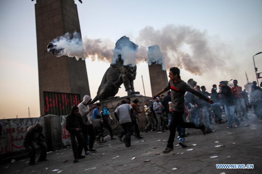 An Egyptian protester throws a teargas back during clashes between anti-government protesters and riot police near Tahrir square in Cairo, March 9, 2013. Two protesters were killed during the clashes. (Xinhua/Amru Salahuddien) 