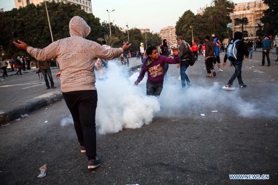An Egyptian protester throws a teargas back during clashes between anti-government protesters and riot police near Tahrir square in Cairo, March 9, 2013. Two protesters were killed during the clashes. (Xinhua/Amru Salahuddien)