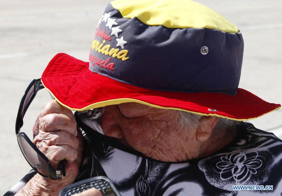 A resident reacts as he waits in the Proceres Avenue to enter the Military Academy of Venezuela to say his last goodbye to President Hugo Chavez, in the city of Caracas, capital of Venezuela, on March 9, 2013. (Xinhua/AVN) 