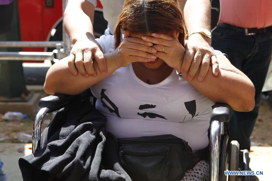A resident reacts as she waits in the Proceres Avenue to enter the Military Academy of Venezuela to say her last goodbye to President Hugo Chavez, in the city of Caracas, capital of Venezuela, on March 9, 2013. (Xinhua/AVN) 