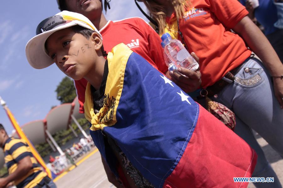 A boy waits in the Proceres Avenue to enter the Military Academy of Venezuela to say his last goodbye to President Hugo Chavez, in the city of Caracas, capital of Venezuela, on March 9, 2013. (Xinhua/AVN) 