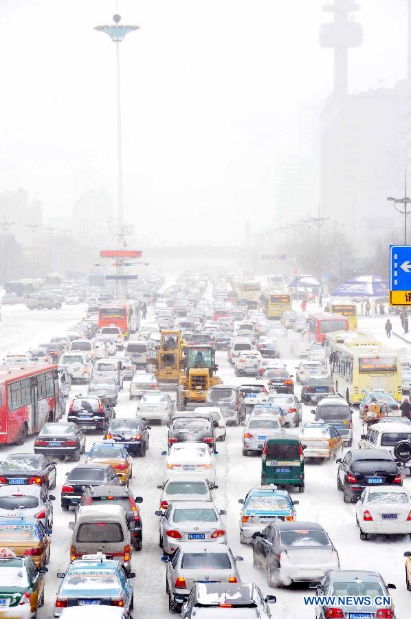 Vehicles run on a snow-covered street in Harbin, capital of northeast China's Heilongjiang Province, March 9, 2013. Local meteorological bureau issued a blue alert against heavy snowfall on Saturday morning. (Xinhua/Wang Song) 