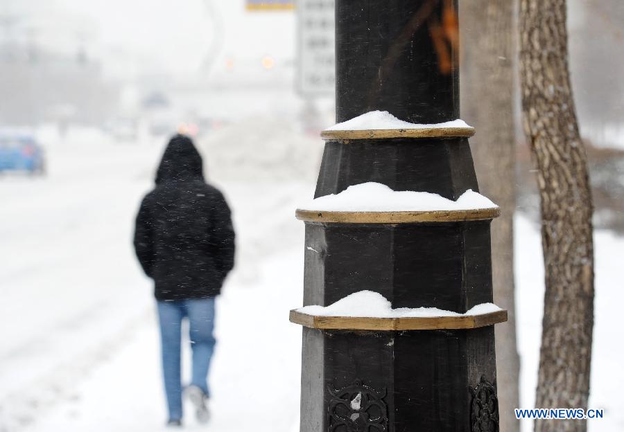 A pedestrian walks on a snow-covered street in Harbin, capital of northeast China's Heilongjiang Province, March 9, 2013. Local meteorological bureau issued a blue alert against heavy snowfall on Saturday morning. (Xinhua/Wang Song) 