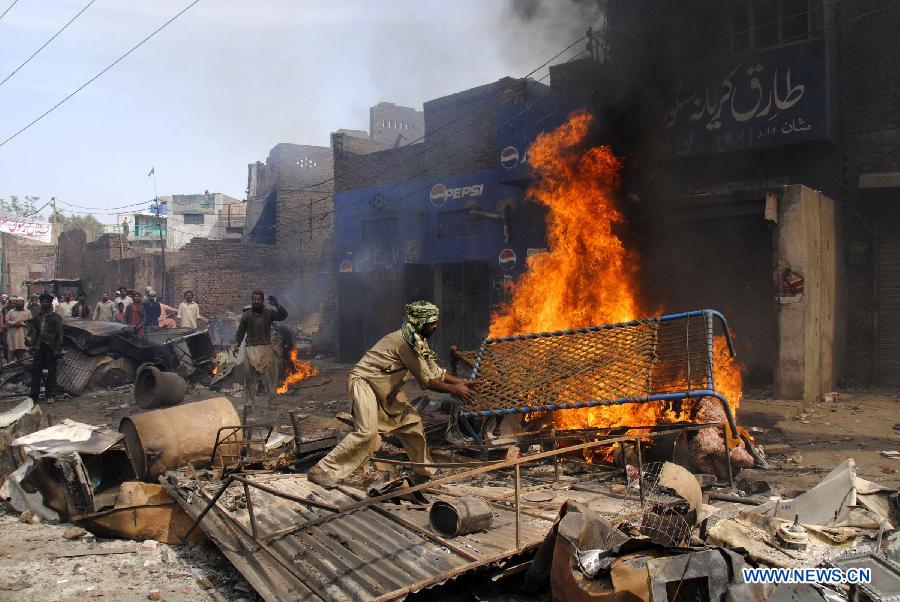 A Pakistani demonstrator torches belongings of Christian families during a protest in a Christian neighborhood in Badami Bagh area of eastern Pakistan's Lahore on March 9, 2013. Hundreds of angry protestors on Saturday set ablaze more than 100 houses of Pakistani Christians over a blasphemy row in the eastern city of Lahore, local media reported. Over 3,000 Muslim protestors turned violent over derogatory remarks allegedly made by a young Christian against Prophet Mohammed in a Christian neighborhood in Badami Bagh area. (Xinhua Photo/Sajjad)