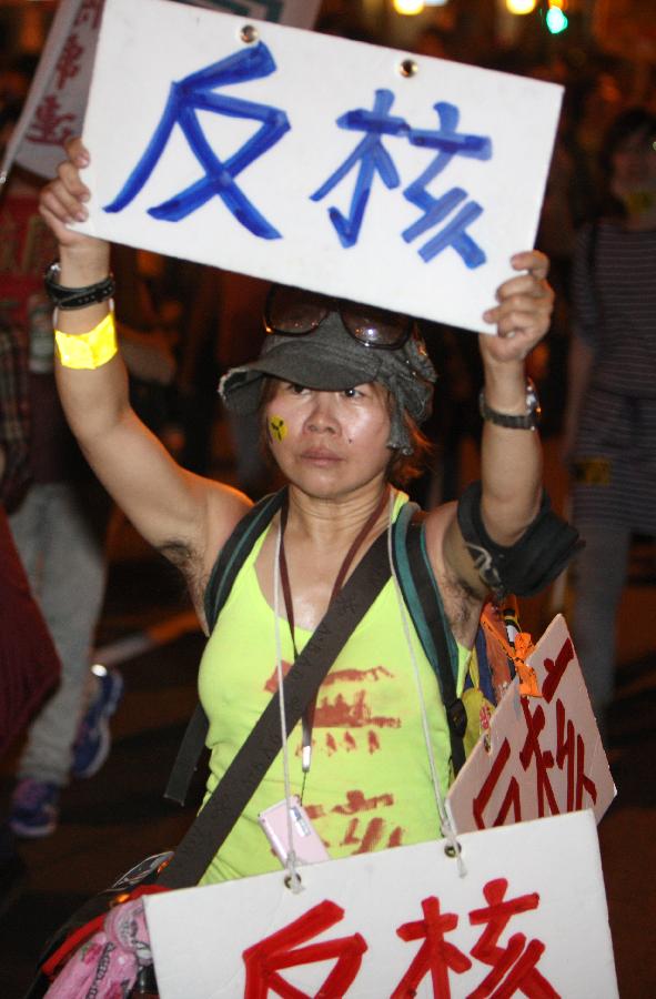 An activist carries placards during an anti-nuclear demonstration in Taipei, southeast China's Taiwan, March 9, 2013. Thousands of anti-nuclear activists around Taiwan took to streets on Saturday to protest against Taiwan's fourth nuclear power plant project, which is supported by local authorities. (Xinhua/Xie Xiudong) 
