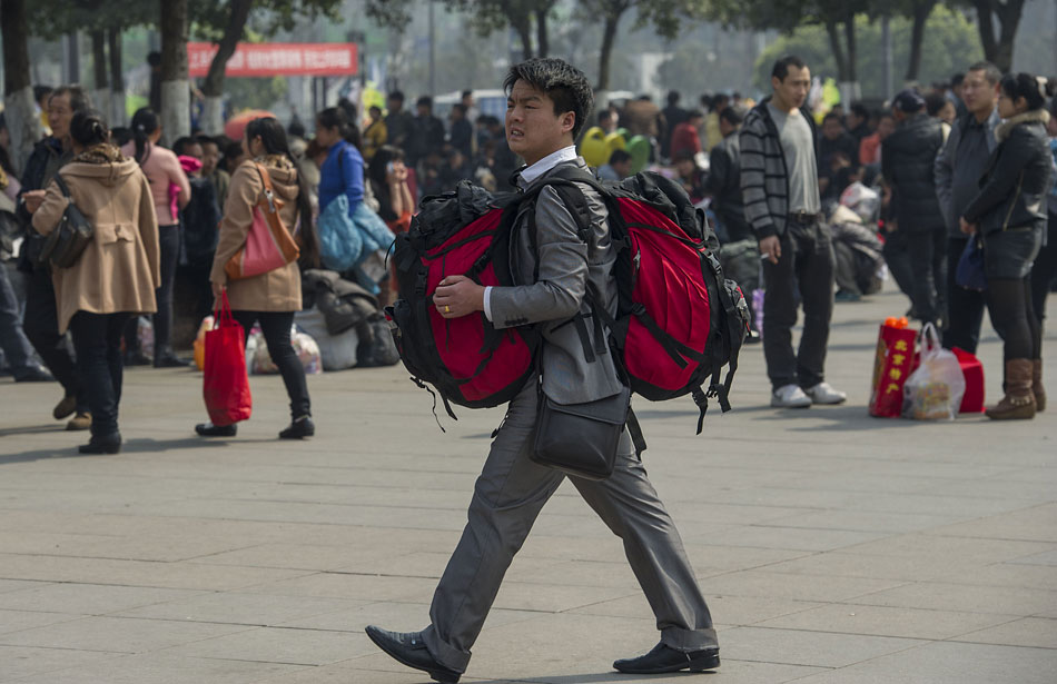 A traveler moves towards the railway station's ticket wicket in Chongqing, Marcg 5, 2013. Though the festival travel season was about to end on Tuesday, Chongqing's railways system witnessed a peak of passengers mainly students and migrant workers, which made ticket hard to get. (Xinhua/Chen Cheng)