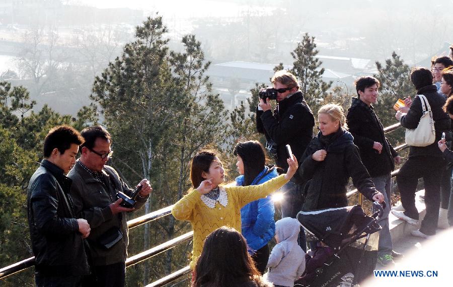 Tourists view Jingshan Park in Beijing, capital of China, March 10, 2013. As the weather turned warmer, many tourists from both home and abroad came to Beijing to visit. (Xinhua/Li Xin)  