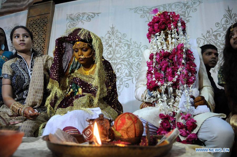A bride and her groom sit during a mass marriage ceremony in southern Pakistani port city of Karachi, on March 9, 2013. The Pakistan Hindu Council organized a mass marriage ceremony with over 50 couples attended. (Xinhua/Masroor)