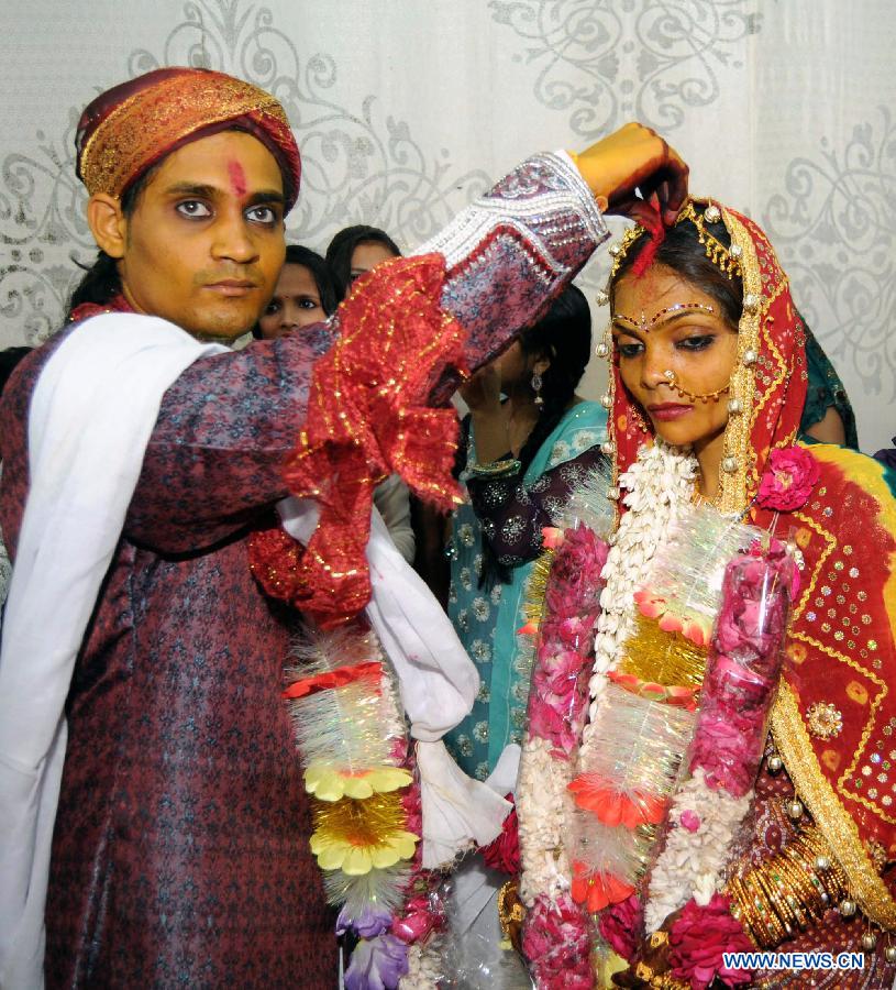 A bride and her groom perform a ritual during a mass marriage ceremony in southern Pakistani port city of Karachi, March 9, 2013. The Pakistan Hindu Council organized a mass marriage ceremony with over 50 couples attended. (Xinhua/Masroor)