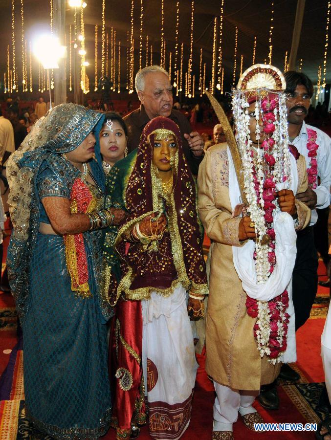 A bride and her groom arrive for a mass marriage ceremony in southern Pakistani port city of Karachi, March 9, 2013. The Pakistan Hindu Council organized a mass marriage ceremony with over 50 couples attended. (Xinhua/Masroor)