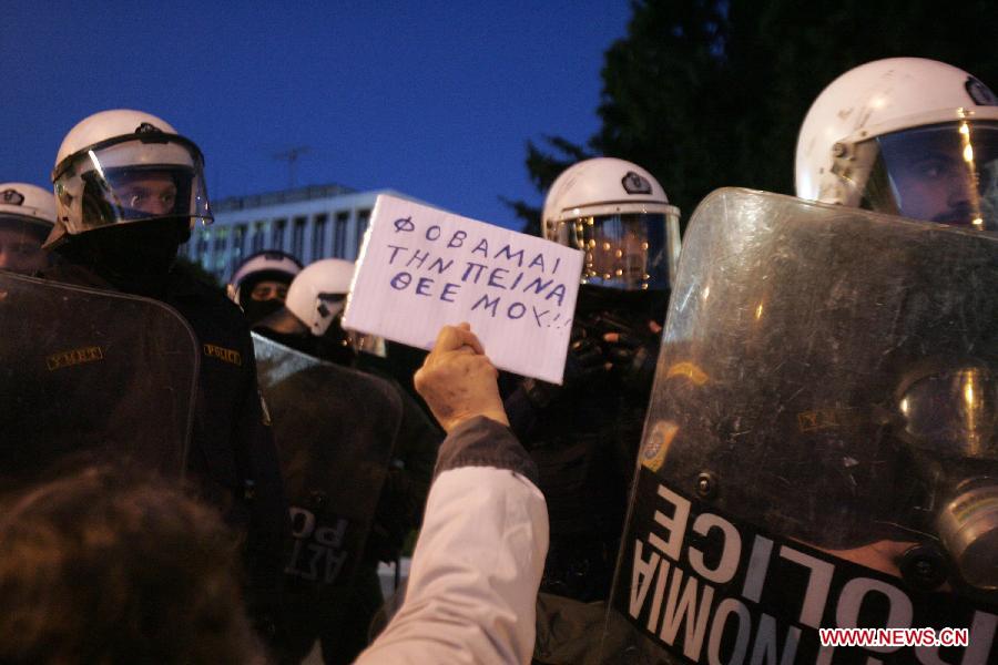 Greek indignant protesters clash with riot police in front of the Parliament in the Greek capital of Athens on March 10, 2013. About 500 indignant protesters come to Syntagma square to protest the harsh and painful austerity measures carried out by the government to counter debt crisis. (Xinhua/Marios Lolos) 