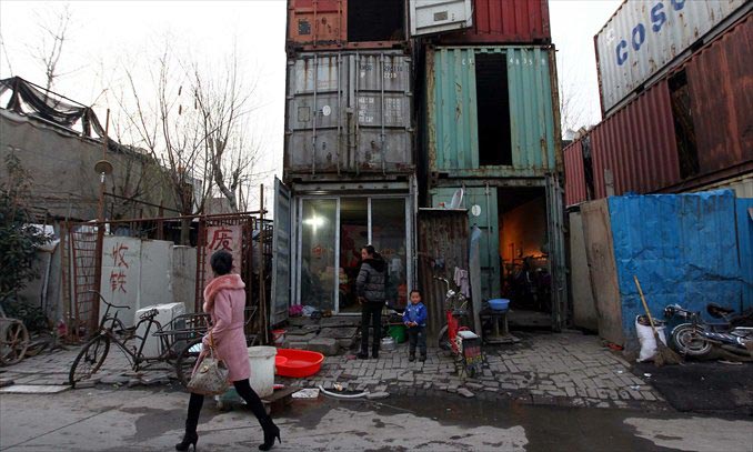 A well-dressed woman walks by shipping container homes in a suburban Shanghai village on March 4. Photo: Yang Hui/GT  
