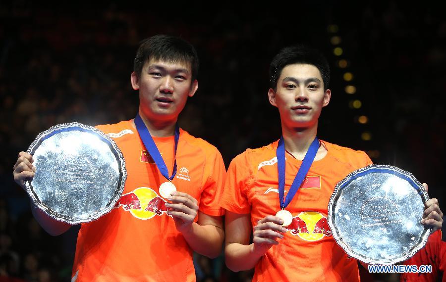 China's Liu Xiaolong (R) and Qiu Zihan present their trophies after winning the men's doubles final against Japan's Hiroyuki Endo/Kenichi Hayakawa at the All England Open Badminton Championships in Birmingham, Britain, March 10, 2013. The Chinese pair won 2-0 to claim the title of the event.(Xinhua/Tang Shi) 