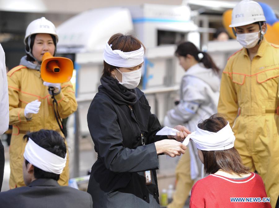 People attend a medical emergency drill in Tokyo, capital of Japan, on March 11, 2013. A drill to take precautions against natural calamities including medical emergency and fire fighting drills was held here to mark the two year anniversary of the March 11 earthquke and ensuing tsunami that left more than 19,000 people dead or missing and triggered a nuclear accident the world had never seen since 1986. (Xinhua/Kenichiro Seki) 