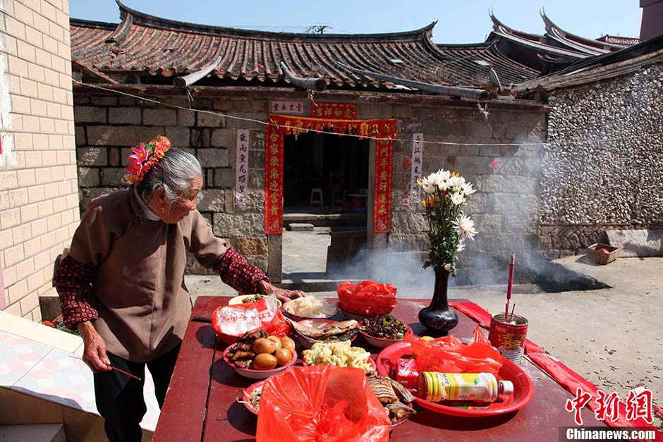 Woman in Xunpu village, Fujian province hold incense sticks to pray for happiness and safety in Xunpu village, Hui'an city of East China's Fujian province, March 10, 2013.(Photo/CNS)
