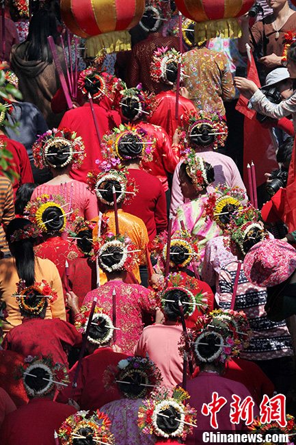 With flowers in their hair, villagers of Xunpu village burn incense in honor of the sea goddess Mazu, March 10, 2013. Every year, the villagers - who are believed to be descendants of Arab traders – don colorful costumers and put fresh flowers in their hair for the festival held on the 29th day of the first lunar month to pray for happiness and safety for those who make a living from the sea near Hui'an city in East China's Fujian province.(Photo/CNS)