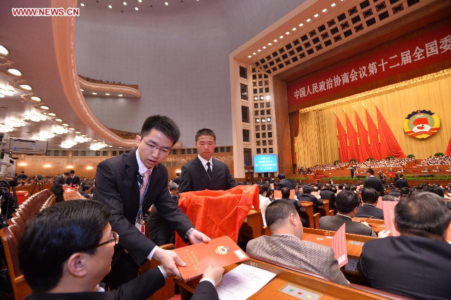 Staff members distribute ballots at the fourth plenary meeting of the first session of the 12th National Committee of the Chinese People's Political Consultative Conference (CPPCC) held at the Great Hall of the People in Beijing, capital of China, March 11, 2013. Chairman, vice-chairpersons, secretary-general and Standing Committee members of the 12th CPPCC National Committee will be elected here on Monday afternoon. (Xinhua/Wang Ye)