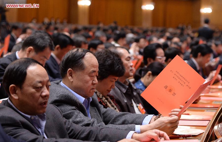 Mo Yan (2nd L), a member of the 12th National Committee of the Chinese People's Political Consultative Conference (CPPCC), checks his ballot at the fourth plenary meeting of the first session of the 12th CPPCC National Committee at the Great Hall of the People in Beijing, capital of China, March 11, 2013. Chairman, vice-chairpersons, secretary-general and Standing Committee members of the 12th CPPCC National Committee will be elected here on Monday afternoon. (Xinhua/Wang Ye)