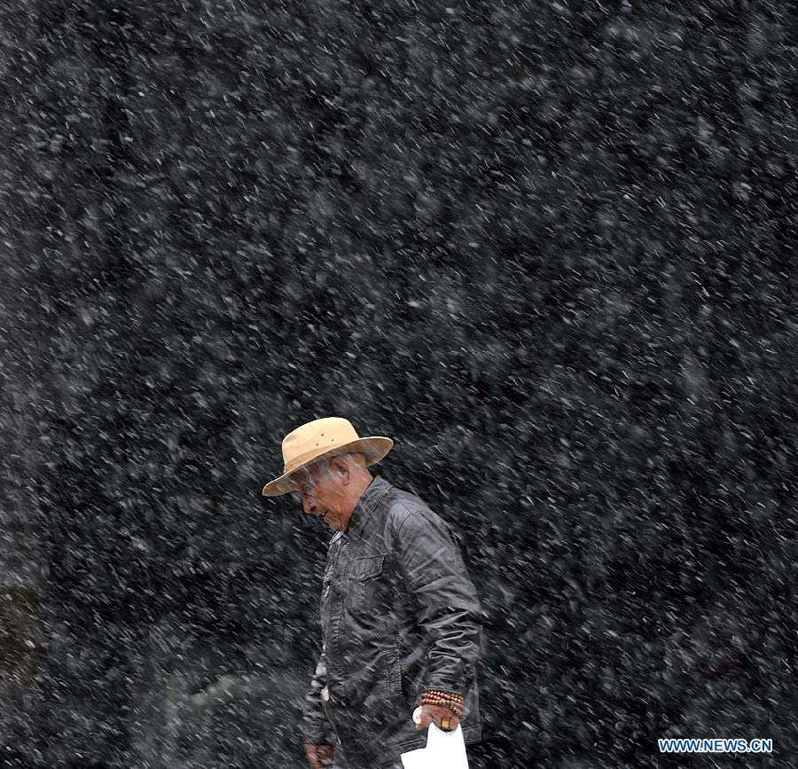 An old man walks in snow in Lhasa, capital of southwest China's Tibet Autonomous Region, March 11, 2013. (Xinhua/Purbu Zhaxi)