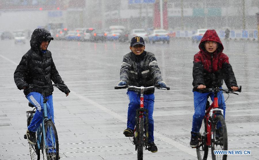 Young boys ride bycicles in snow in Lhasa, capital of southwest China's Tibet Autonomous Region, March 11, 2013. (Xinhua/Liu Kun)