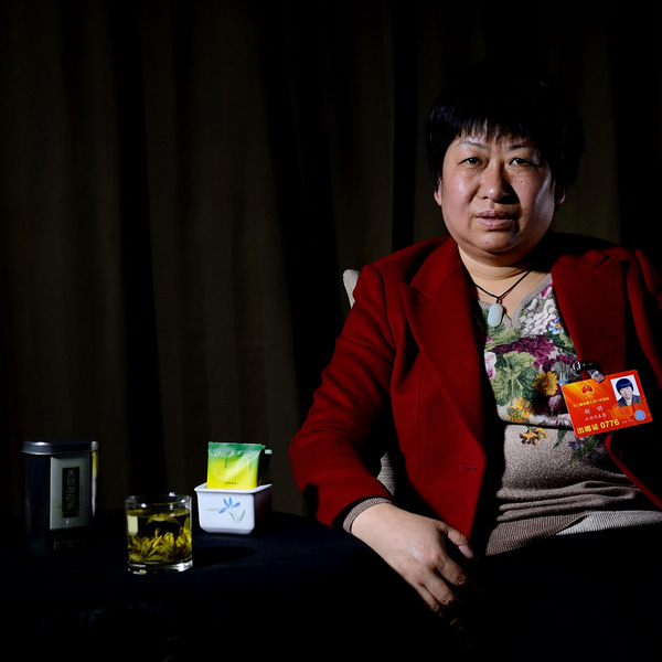 Hu Ming poses with her tea in Beijing, on March 6, 2013. Hu, an NPC deputy and manager of Xingzhu Livestock and Poultry Breeding Research Center in Liyang, East China's Jiangsu province, has strived for 25 years to realize her dream of owning a farm with 200,000 hens. [Photo/Xinhua]